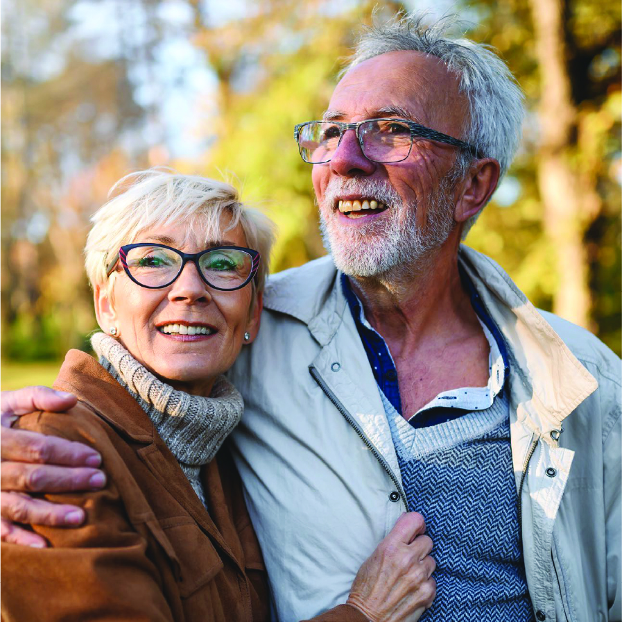 Elderly couple hugging affectionately outdoors